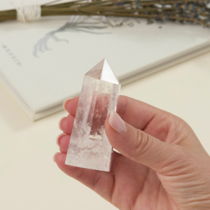 clear quartz crystal tower for sale held in a woman's hand